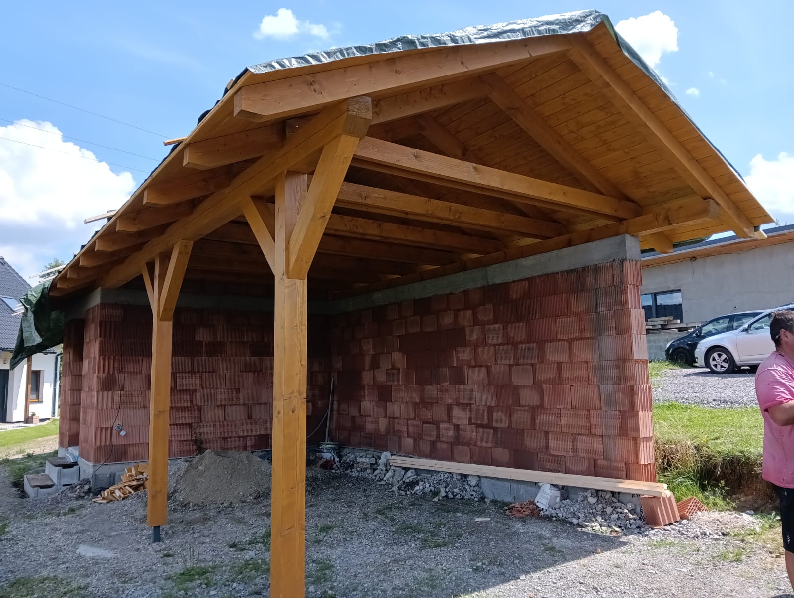 Dřevěný přístřešek s krovem na hrubé stavbě